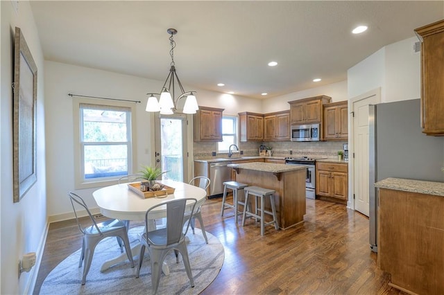 dining room with recessed lighting, baseboards, and dark wood finished floors