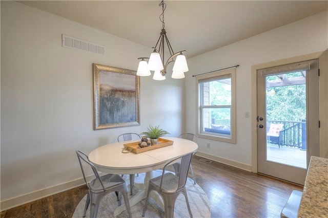 dining space with baseboards, visible vents, and wood finished floors