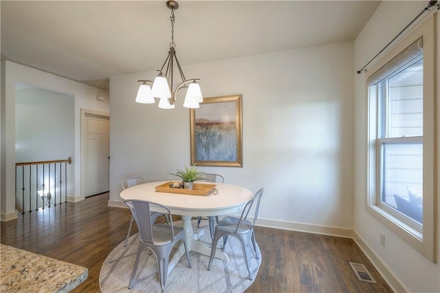 dining room with baseboards, a notable chandelier, dark wood-style floors, and visible vents