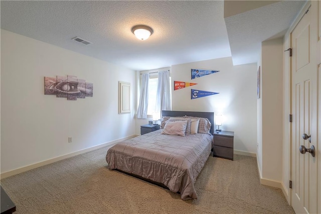 carpeted bedroom with a textured ceiling, baseboards, and visible vents