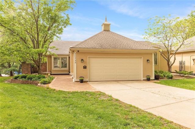 view of front of home with an attached garage, stucco siding, a front yard, and concrete driveway
