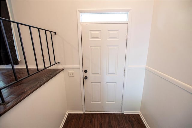 doorway to outside featuring dark wood-style flooring and baseboards