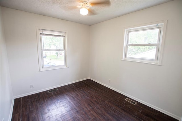 unfurnished room with dark wood finished floors, ceiling fan, baseboards, and a textured ceiling