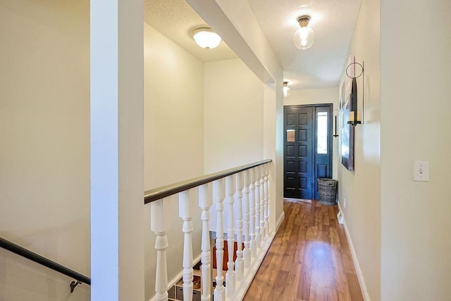corridor featuring wood finished floors and baseboards
