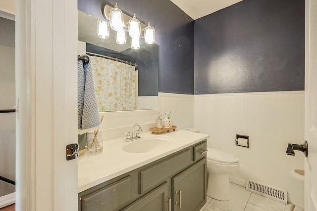 full bath with a wainscoted wall, toilet, vanity, and a shower with curtain