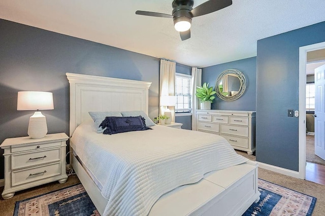 bedroom featuring baseboards, dark carpet, and ceiling fan