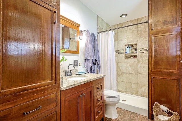 full bathroom featuring toilet, a shower stall, wood finished floors, and vanity