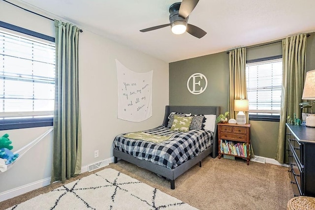 bedroom with light colored carpet, baseboards, and ceiling fan
