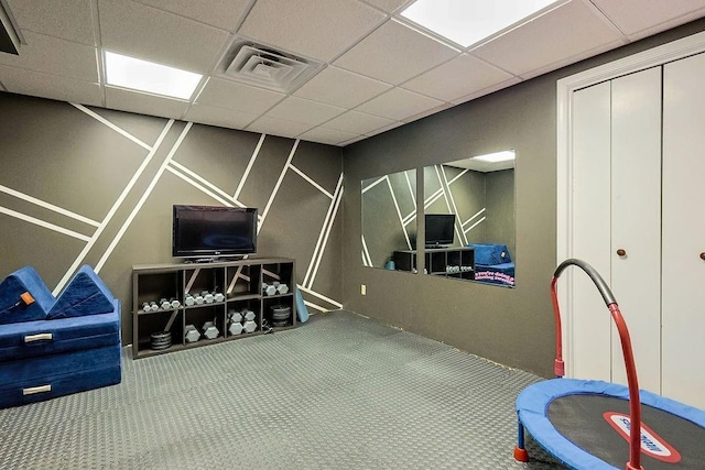 recreation room with a paneled ceiling and carpet