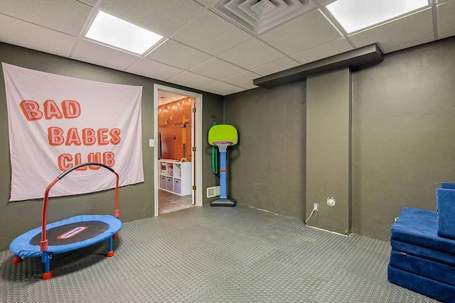 interior space with a paneled ceiling and carpet flooring