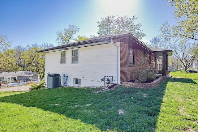 view of property exterior featuring central AC and a yard