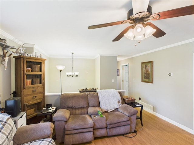 305 California Ave, Windsor, MO 65360 - living area featuring light wood finished floors, crown molding, baseboards, a chandelier, and a ceiling fan