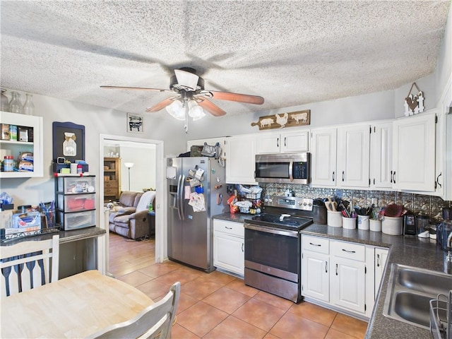 305 California Ave, Windsor, MO 65360 - kitchen featuring appliances with stainless steel finishes, dark countertops, a ceiling fan, white cabinets, and a textured ceiling