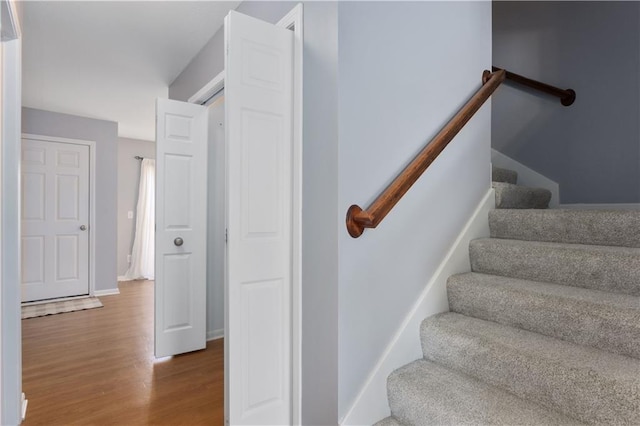 staircase with wood finished floors and baseboards