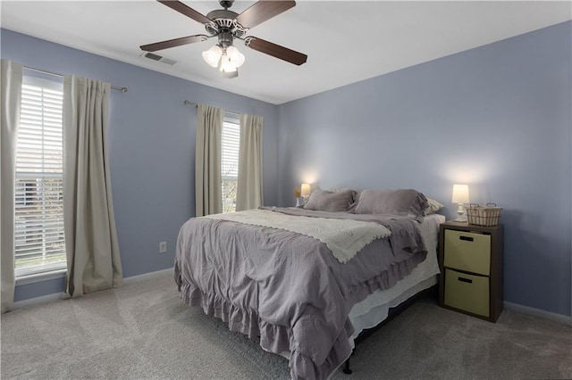 carpeted bedroom featuring baseboards, a ceiling fan, and visible vents