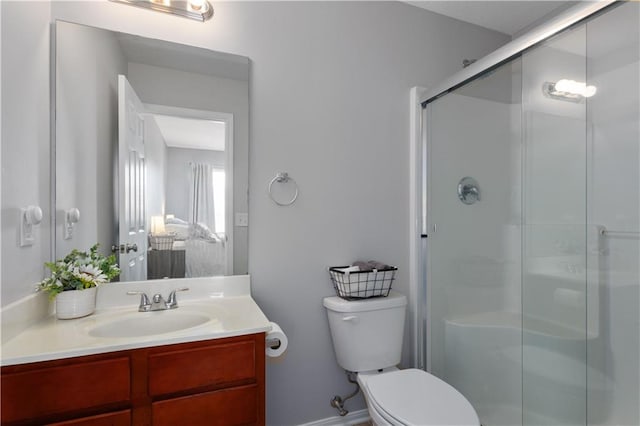 bathroom with vanity, a shower stall, and toilet