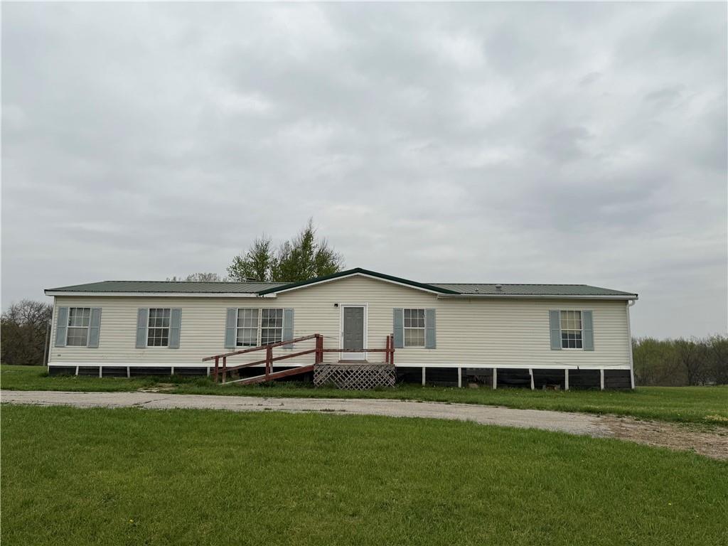 manufactured / mobile home featuring a wooden deck and a front yard