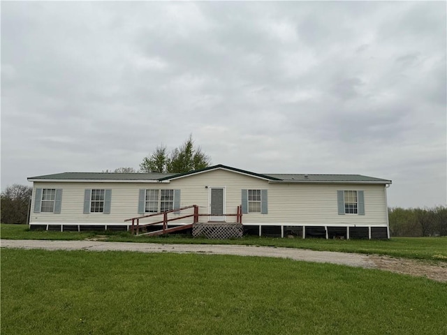 manufactured / mobile home featuring a wooden deck and a front yard