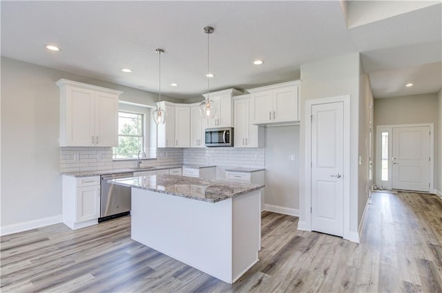 1828 N 92nd Ter, Kansas City, KS 66112 - kitchen with light wood-type flooring, appliances with stainless steel finishes, a center island, and a sink