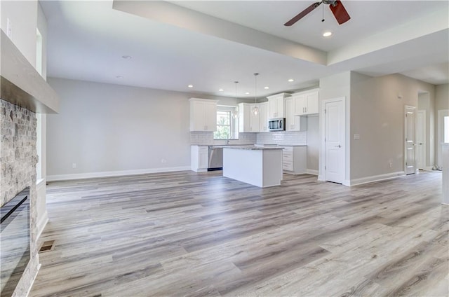 1828 N 92nd Ter, Kansas City, KS 66112 - unfurnished living room with recessed lighting, light wood-style floors, baseboards, a fireplace, and ceiling fan