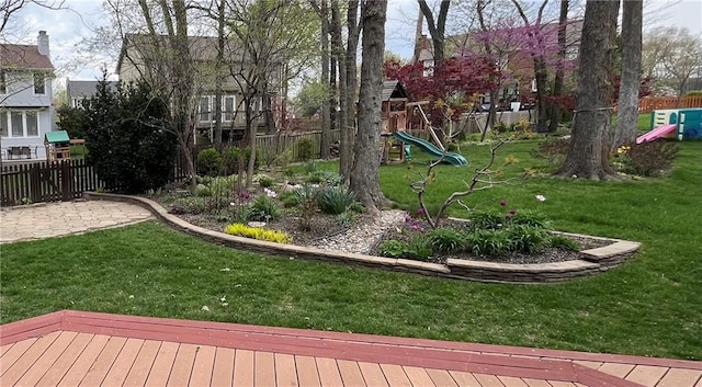 view of yard with fence and a playground