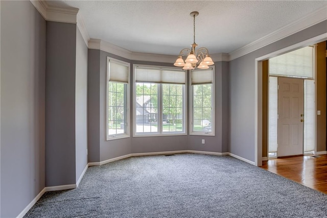 carpeted empty room featuring baseboards, ornamental molding, and an inviting chandelier