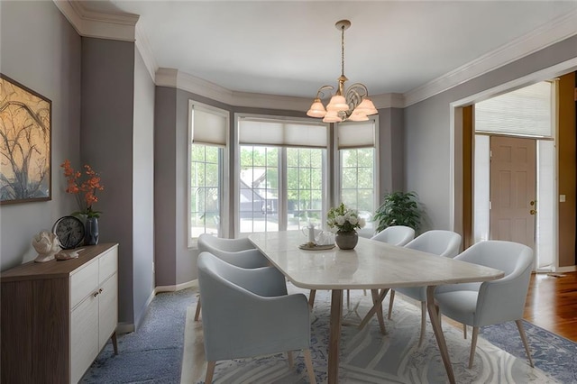 dining area with baseboards, a chandelier, and ornamental molding