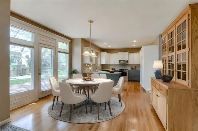 dining space with recessed lighting and light wood finished floors