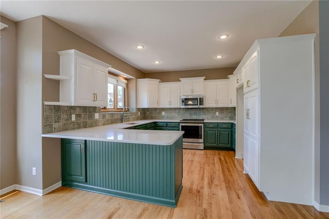 kitchen with white cabinets, stainless steel appliances, a peninsula, tasteful backsplash, and open shelves