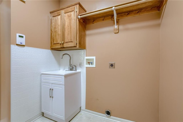 laundry room with a sink, hookup for an electric dryer, light tile patterned flooring, cabinet space, and washer hookup
