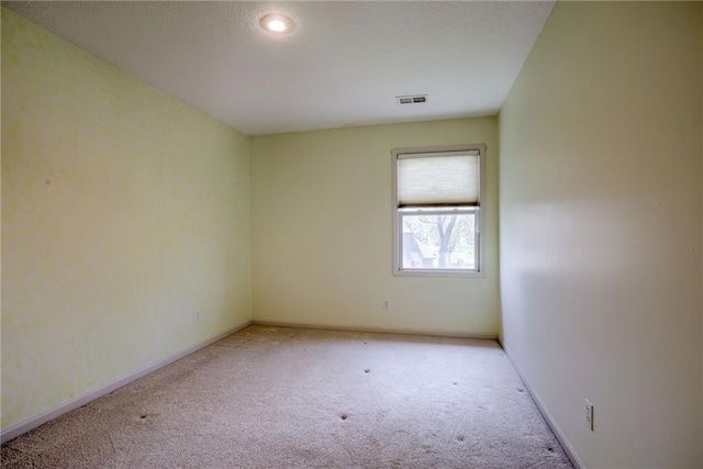 spare room with visible vents, carpet flooring, and baseboards