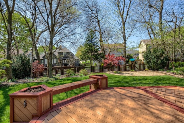wooden terrace with a fenced backyard, a fire pit, a yard, and a residential view