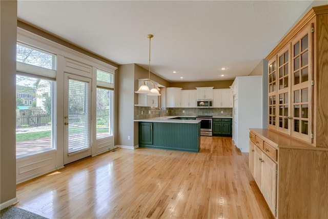 915 NE 102nd St, Kansas City, MO 64155 - kitchen featuring stainless steel appliances, backsplash, light wood-style flooring, and glass insert cabinets