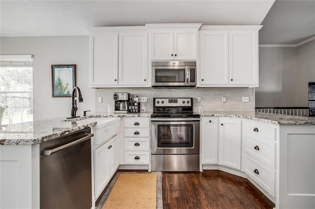 3204 SW Alice Ln, Lees Summit, MO 64082 - kitchen with dark wood-type flooring, a peninsula, light stone counters, and stainless steel appliances