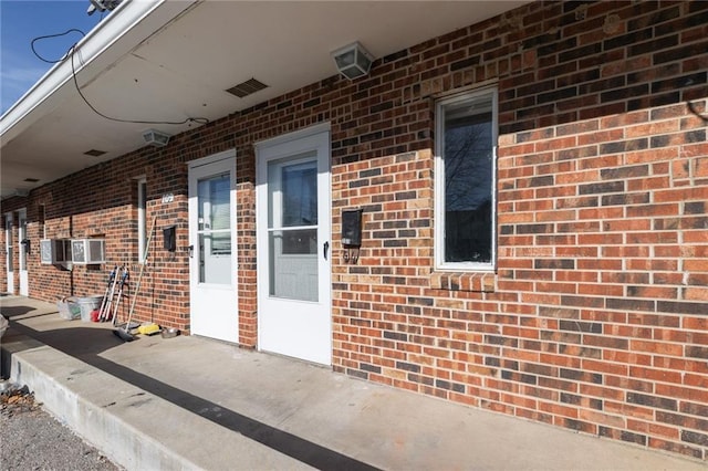 view of exterior entry with brick siding