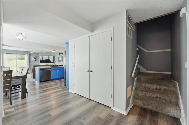 staircase featuring wood finished floors and baseboards