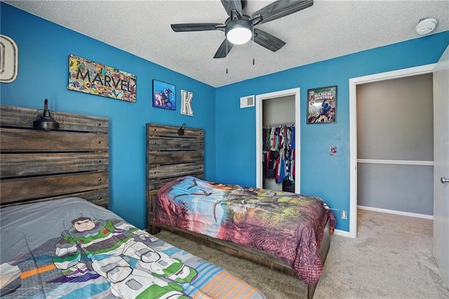 bedroom featuring carpet flooring, a textured ceiling, a closet, baseboards, and a ceiling fan