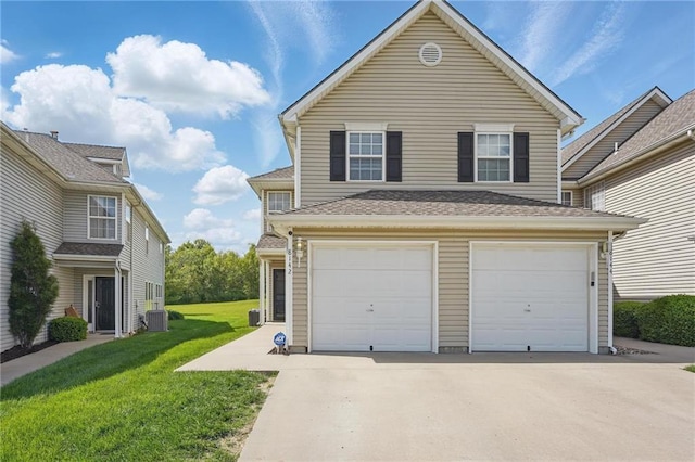 view of front of home featuring driveway, a garage, a front yard, and central AC unit