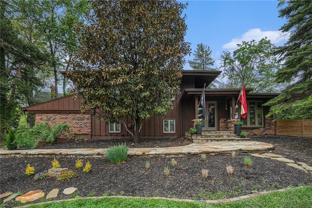 back of property featuring board and batten siding and brick siding