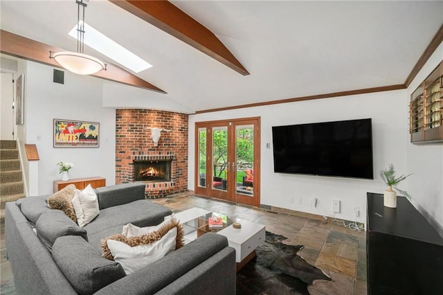 living room featuring a fireplace, stairway, baseboards, stone tile flooring, and vaulted ceiling with beams