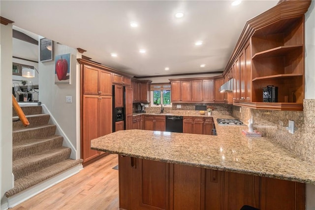 kitchen with a peninsula, ventilation hood, paneled built in refrigerator, a sink, and dishwasher