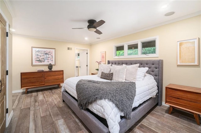 bedroom featuring crown molding, baseboards, visible vents, and wood finished floors