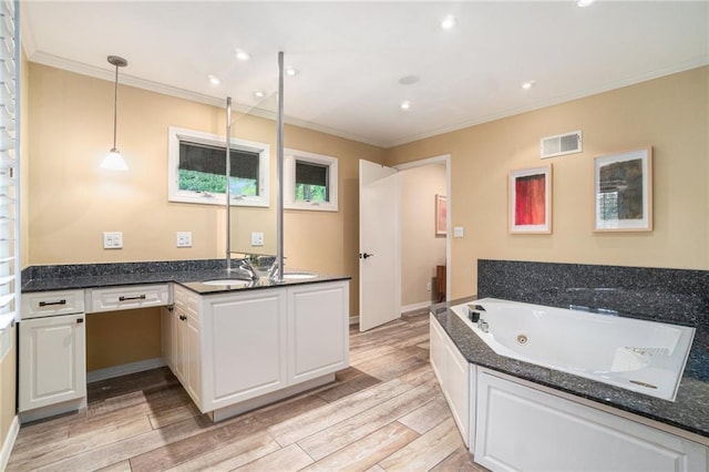 bathroom with vanity, a whirlpool tub, wood finished floors, visible vents, and ornamental molding