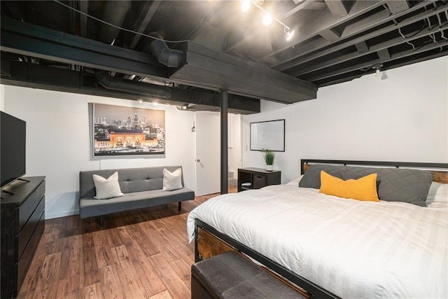 bedroom with baseboards and wood finished floors
