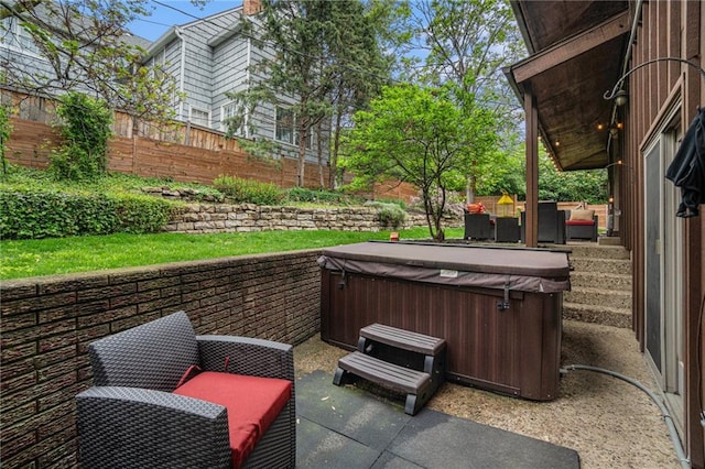 view of patio / terrace featuring a hot tub and fence