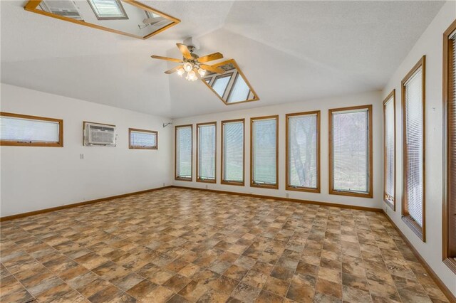 20 SE E Hwy, Trenton, MO 64683 - spare room with lofted ceiling with skylight, an AC wall unit, baseboards, and a ceiling fan