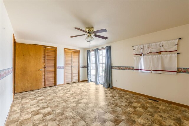 20 SE E Hwy, Trenton, MO 64683 - unfurnished room featuring visible vents, a ceiling fan, baseboards, and stone finish floor