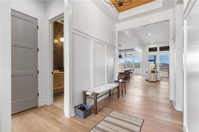 14511 S Dawson St, Olathe, KS 66061 - corridor with light wood-type flooring, a chandelier, and a decorative wall