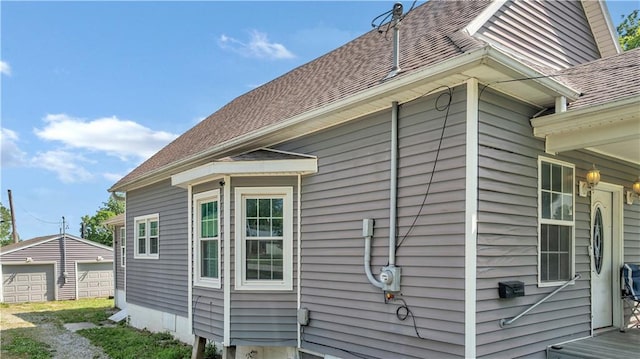 812 Pacific Ave, Osawatomie, KS 66064 - view of home's exterior featuring an outbuilding, a shingled roof, and a detached garage
