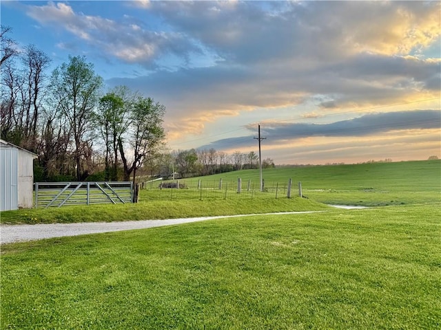 view of community with fence, a rural view, and a yard